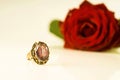 A ring with a sapphire on a background of a red rose Royalty Free Stock Photo