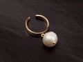 Ring with white baroque pearl on brown leather background