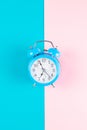Ringing twin bell classic alarm clock isolated on blue and pink pastel colorful geometric background. Rest hours time of life good