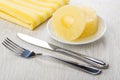 Rings of canned pineapple in saucer, napkin, knife and fork Royalty Free Stock Photo