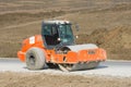 Rink evens gravel, preparing the way for the laying of asphalt