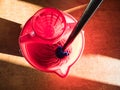 Rinsing out a mop in red bucket of water Royalty Free Stock Photo