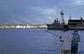 Fishermen in the port area, and view of Niteroi city in the background