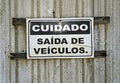 Old warning sign in portuguese informing `CAUTION VEHICLE EXIT` Royalty Free Stock Photo