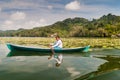 RIO DULCE, GUATEMALA - MARCH 10, 2016: Local indigenous woman paddling across Rio Dulce river, Guatema