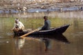 Rio Nilo, near Aswnm, Egypt, February 21, 2017: Two Egyptian fishermen in a small boat fishing, one of them crouched in the stern Royalty Free Stock Photo