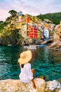 Riomaggiore Cinque Terre Italy , colorful village harbor front by the ocean, young woman watching sunset Royalty Free Stock Photo