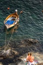 Riomaggiore, Cinque Terre, Italy - 26 June 2018: Toursist honeymoon couple viewing the sunset with a boat at Riomaggiore across