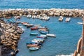 Marina with boats and rocks in the sea of Riomaggiore in Italy. Some vacationers people. Blue