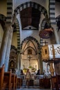 Riomaggiore ITALY - 2 August 2023 - Tourist in interior of San Giovanni Battista church in low light