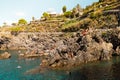 Riomaggiore, Italy - 3 august 2020: young beach goers jump and dive from cliffs in the italian riviera enjoying summer holidays Royalty Free Stock Photo