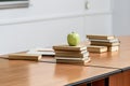 ripe apple on stack of books on table in lecture room Royalty Free Stock Photo