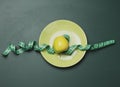 Ripe apple wrapped with a centimeter on a green background, body weight control concept Royalty Free Stock Photo