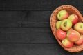 Ripe apples in a basket on wooden background