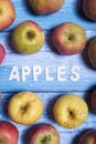 Ripe apples colorful fruit with apples wooden word on a blue board