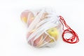 Ripe apples packed in a white reusable mesh bag with red string, isolated on a white background. Royalty Free Stock Photo