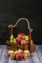 Ripe apples, pears and peaches in a wooden box Royalty Free Stock Photo