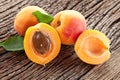 Ripe apricot fruits with slices and apricot leaves on a old wooden table Royalty Free Stock Photo