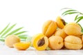 Ripe apricots in droplets of water on a white wooden table.