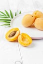 Ripe apricots on a round plate on a white board with a close-up.. Royalty Free Stock Photo