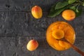 Ripe apricots and a wooden spoon in apricot jam on a wooden table. Royalty Free Stock Photo