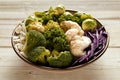 Ripe assorted cabbages in bowl on table Royalty Free Stock Photo