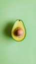 Ripe avocado cut in half showing the seed, resting on a vibrant green backdrop, creating a visually appealing contrast and Royalty Free Stock Photo