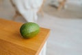 Ripe avocado fruit without retouching natural look on wooden countertop of kitchen. real-life moment, selective focus