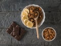 Ripe banana, almonds and quinoa porridge with cocoa on a rustic table. Flat lay.