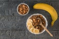Ripe banana, almonds and quinoa porridge with cocoa on a wooden table. Flat lay.