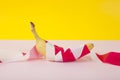 a ripe banana, wrapped in a red and white plastic ribbon