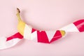 a ripe banana, wrapped in a red and white plastic ribbon