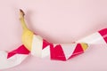 a ripe banana, wrapped in a red and white plastic ribbon