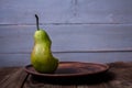 A bite pear on a plate on wooden background Royalty Free Stock Photo