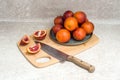 Ripe bloody Sicilian orange sliced on a cutting board. Blood orange slices and a knife