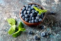 ripe blueberries in bowl on a dark concrete background