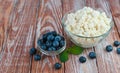 Ripe blueberries and cottage cheese on the wooden table. Healthy breakfast. Close-up. Place for text Royalty Free Stock Photo