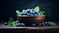 Ripe blueberries and fresh spearmint in clay bowl on wooden table for healthy eating concept
