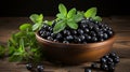 Ripe blueberries and spearmint in clay bowl on wood table, health and wellness concept