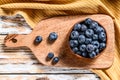 Ripe blueberries in a wooden bowl. White wooden background. Top view Royalty Free Stock Photo