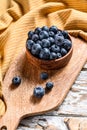 Ripe blueberries in a wooden bowl. White wooden background. Top view Royalty Free Stock Photo