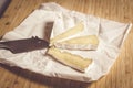 Ripe brie cheese cut into slices on paper with mouse shaped knife