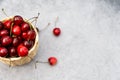 Ripe cherries in a basket on a light gray granite background. Tope view