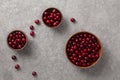 Ripe cherries in a clay bowl on gray concrete, top view