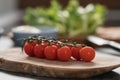 Ripe cherry tomatoes on branch on olive wood board Royalty Free Stock Photo