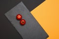 Ripe cherry tomatoes composed on black slate boards on colorful background Royalty Free Stock Photo