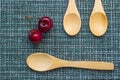 Ripe cherry on a wicker background and three wooden spoons, close-up Royalty Free Stock Photo