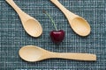 Ripe cherry on a wicker background and three wooden spoons, close-up Royalty Free Stock Photo