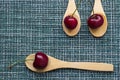 Ripe cherry on a wicker background and three wooden spoons, close-up Royalty Free Stock Photo