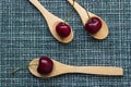 Ripe cherry on a wicker background and three wooden spoons, close-up Royalty Free Stock Photo